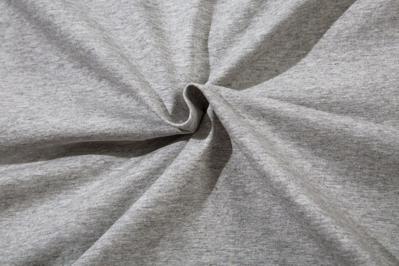 Close-up of the light gray tee fabric gathered into a twist at the center