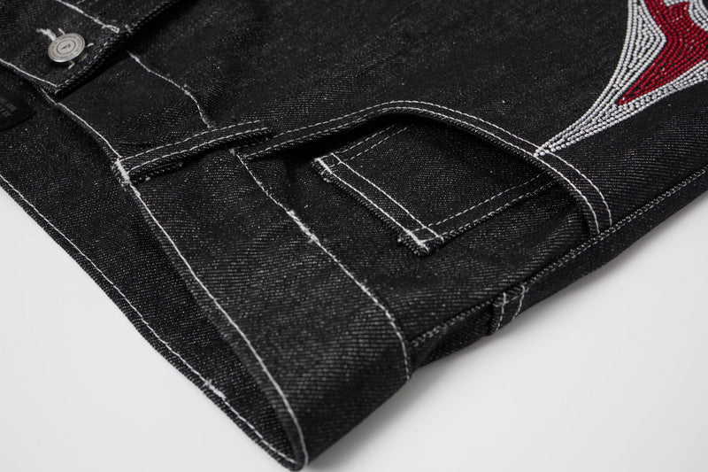 Close-up of black denim hem and cuff with white contrast stitching