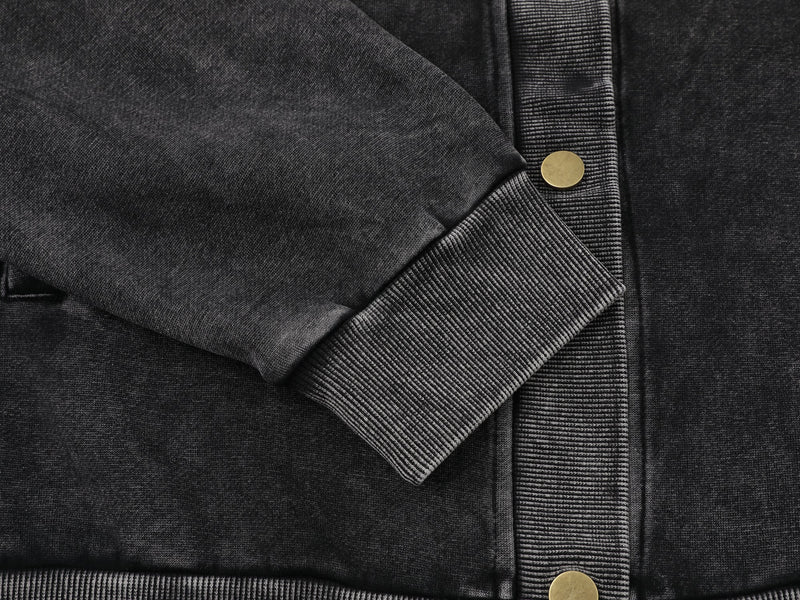 Close-up of black jacket sleeve cuff and snap front placket