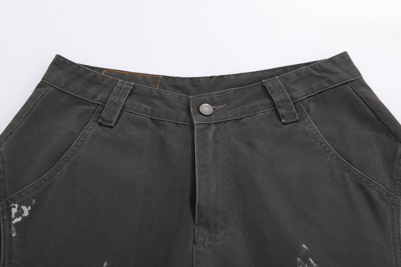 Black shorts waistband close-up with button closure, belt loops, and front pocket detail