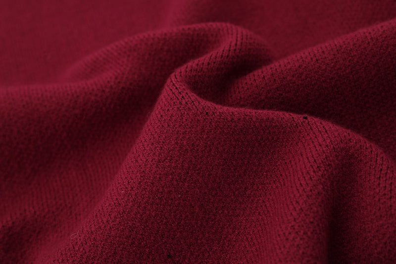 Close-up of burgundy knit fabric folds with soft textured surface