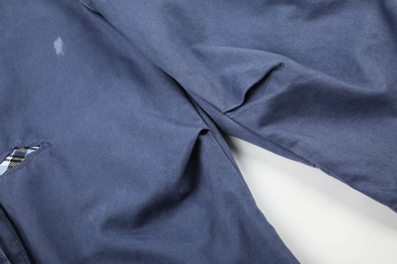 Close-up of blue cargo shorts leg fabric with distressed mark and torn edge