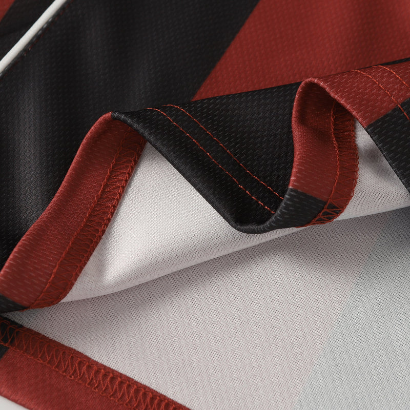 Close-up of retro soccer jersey fabric with black and red vertical stripes and white mesh detailing