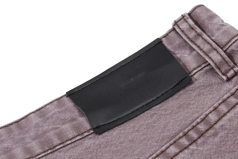 Close-up of black waistband patch on brown denim