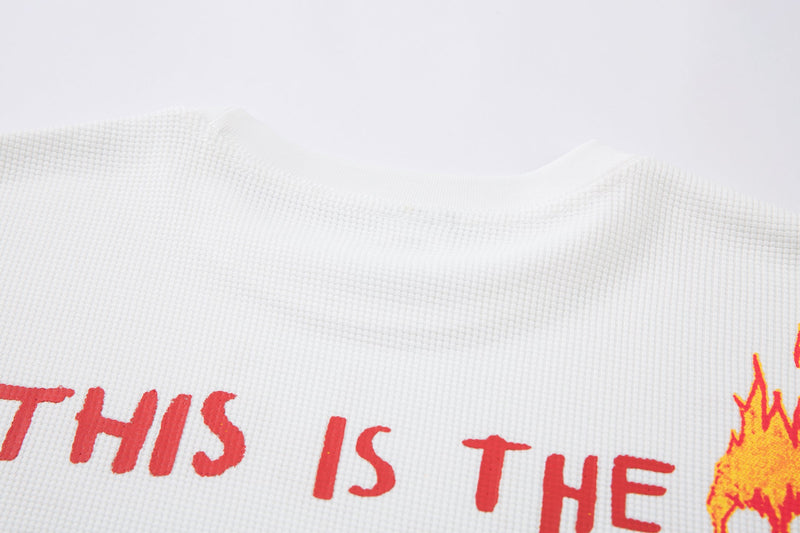 Close-up of white waffle knit fabric and upper front red print with flame detail