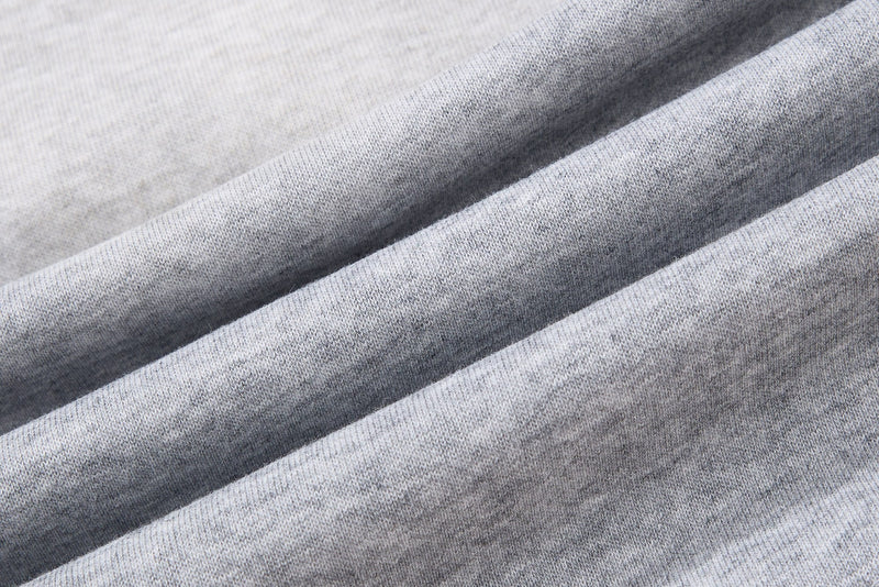Close-up of light gray heathered fabric with diagonal folds