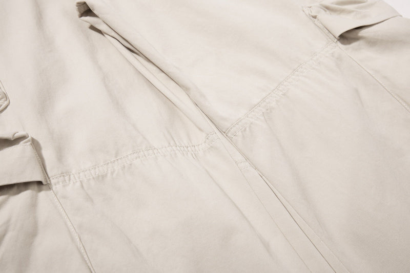 Close-up of beige cargo pants paneling and topstitching on the leg