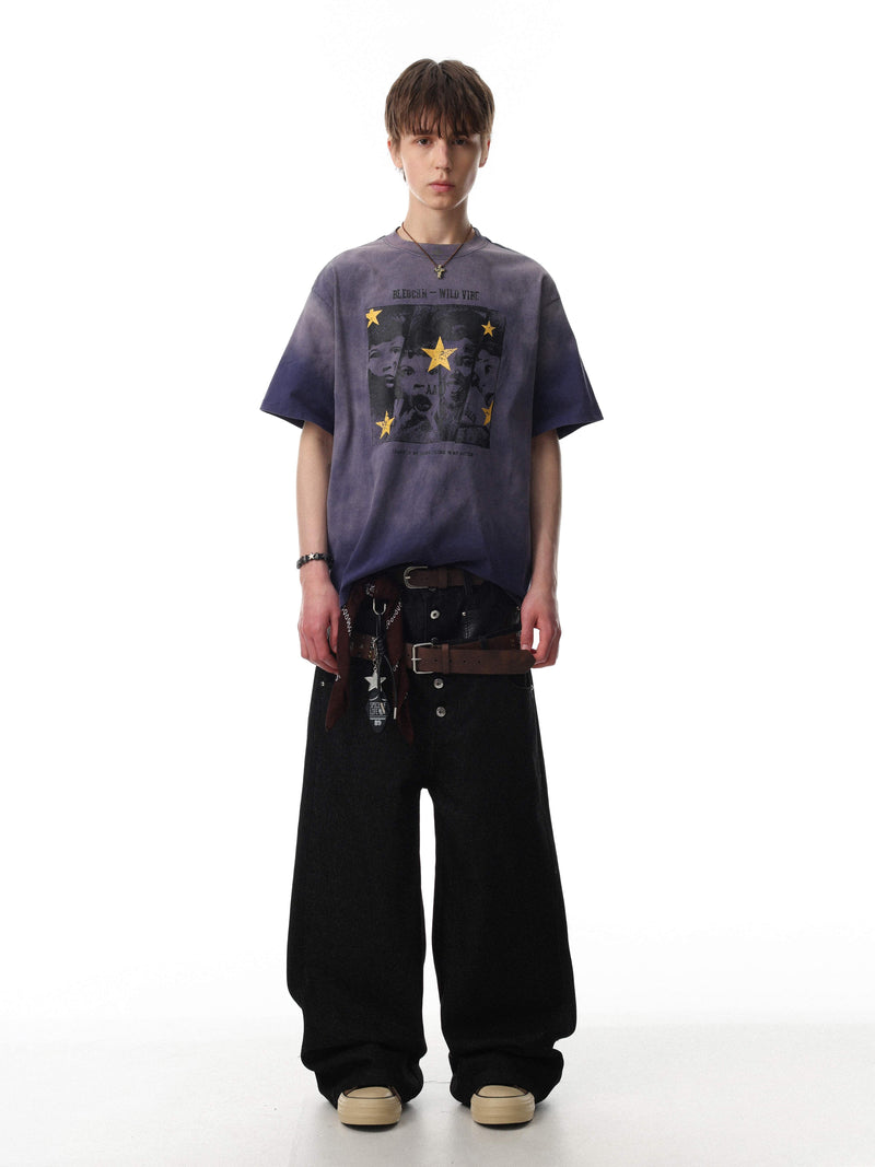 Vintage washed purple graphic tee with star print, worn with wide black trousers in a streetwear look