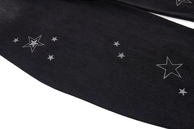 Close-up of star print on black denim leg