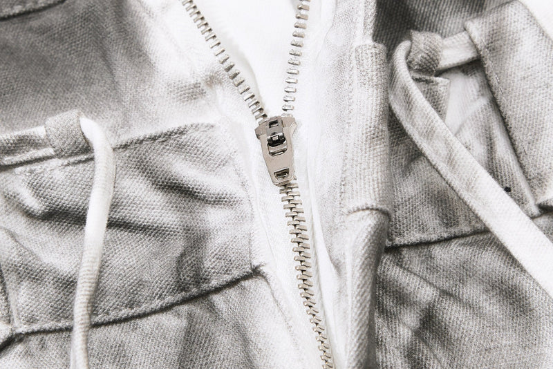 Close-up of metal zipper and white drawstring on gray balloon jeans