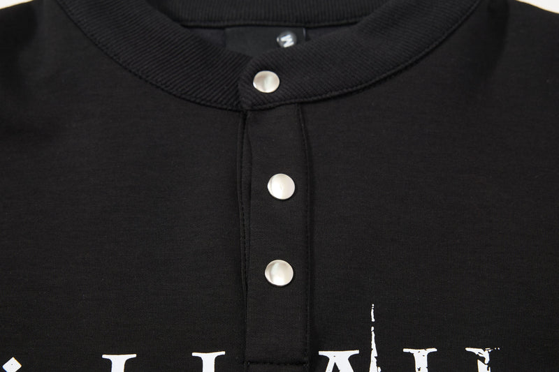 Black polo tee with snap buttons and a ribbed collar, featuring a bold medieval graphic print on the front