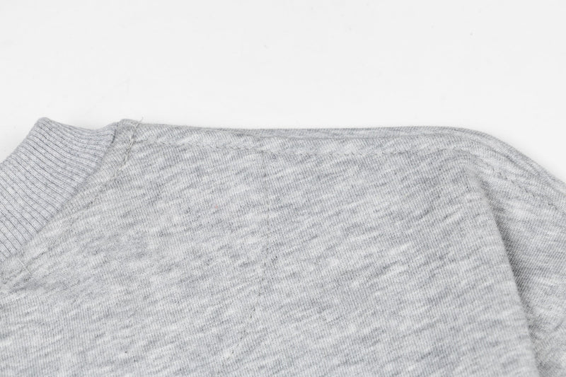 Close-up of heather gray sleeve and shoulder seam with soft jersey texture