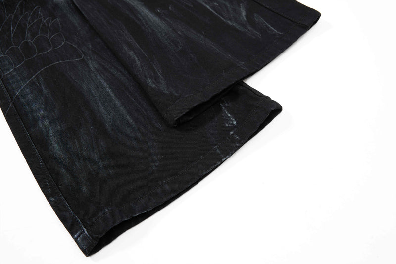 Close-up of black flare leg hem with washed denim texture
