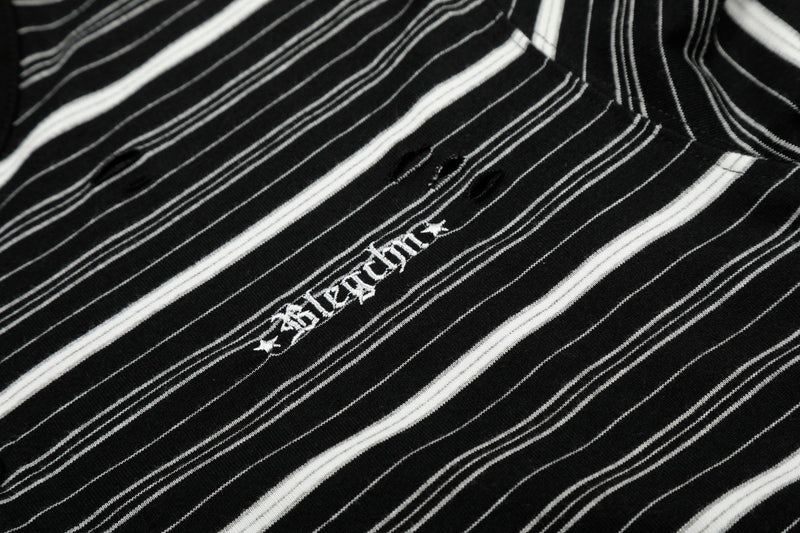 Close-up of chest embroidery and distressed holes on black striped Henley tee
