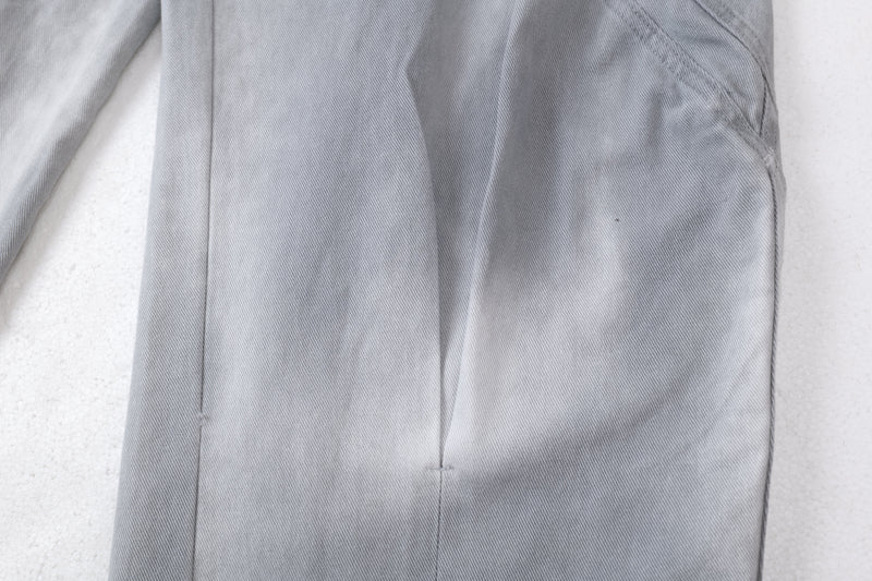 Close-up of the lower leg panel seam on light gray denim jeans