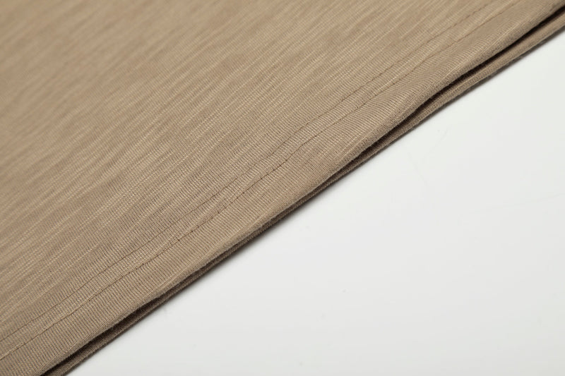 Close-up of brown tee hem with fine ribbed texture and stitching
