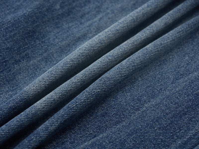 Close-up of blue denim fabric texture with soft folds