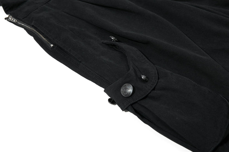 Close-up of black shorts side seam with zip pocket and buttoned cargo pocket flap