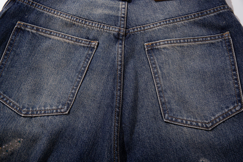 Close-up of back pockets and center seam on mid-blue washed denim jeans