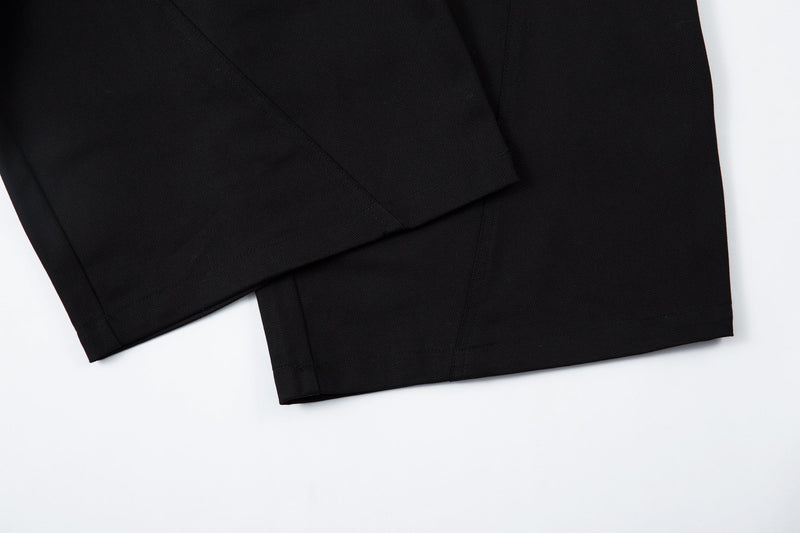 Close-up of hem and lower leg of black wide-leg trousers