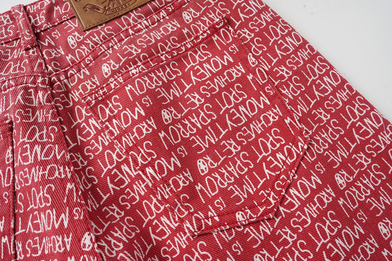 Close-up of red script print pants back pocket and waistband seam