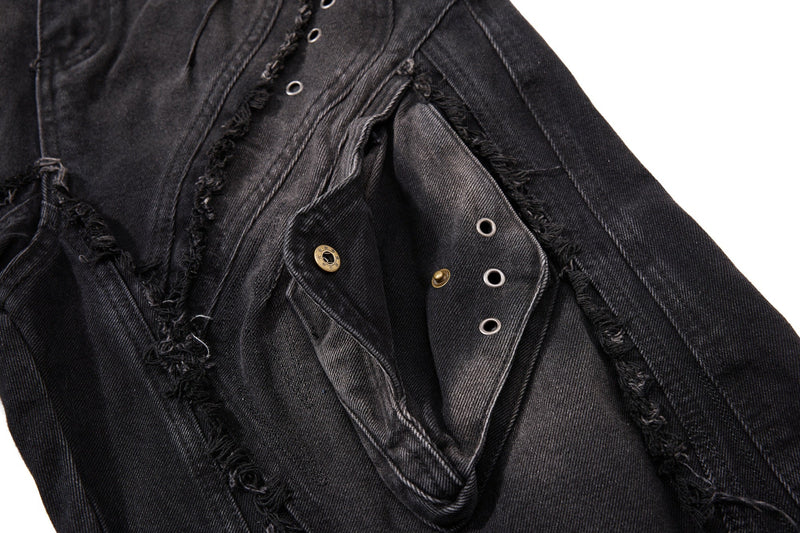 Close-up of distressed black denim side panel with metal eyelets and frayed seams