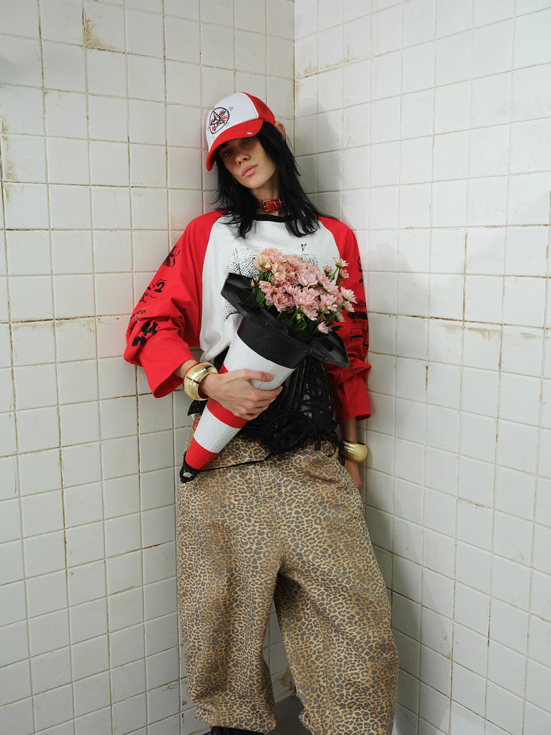 Model holding bouquet in red and white graphic raglan long-sleeve T-shirt