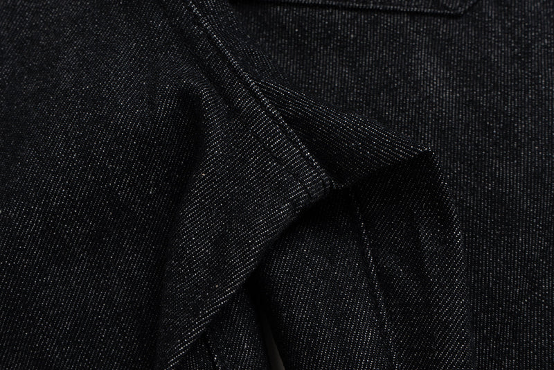 Close-up of folded black denim fabric with visible texture