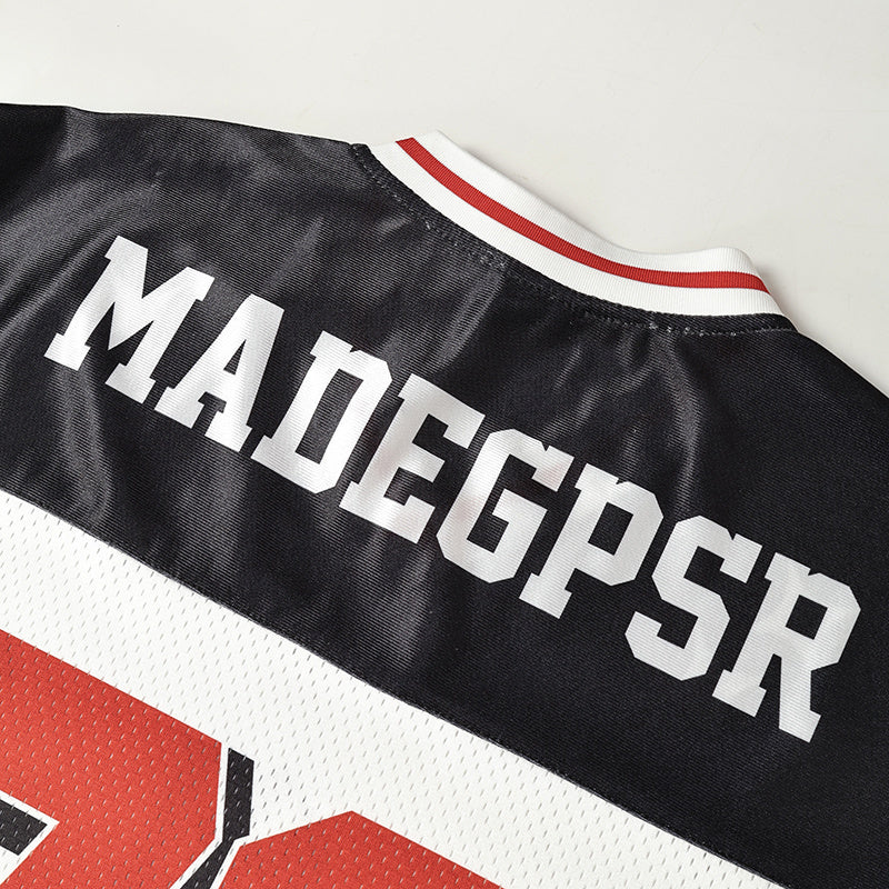 Black heritage block football jersey with white MADEGPSR lettering, red trim, and mesh fabric detail