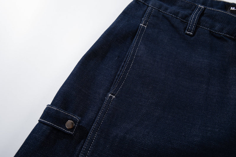 Close-up of a side cargo pocket and seam on deep-indigo denim