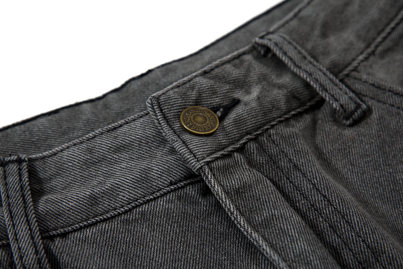 Close-up of front waistband button and belt loop on black denim
