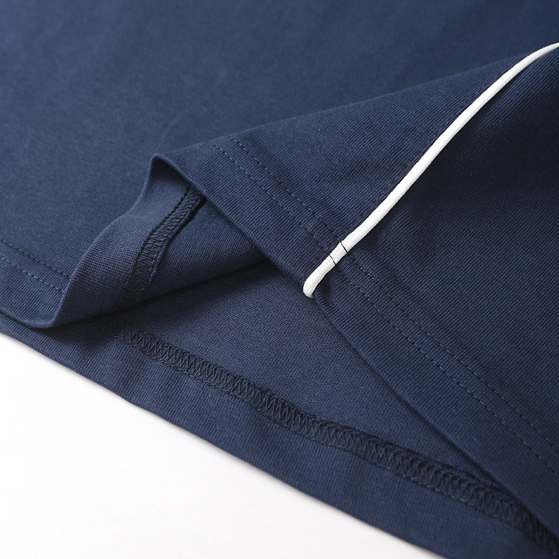 Close-up of a navy cotton athletic T-shirt hem with white piping and detailed stitching