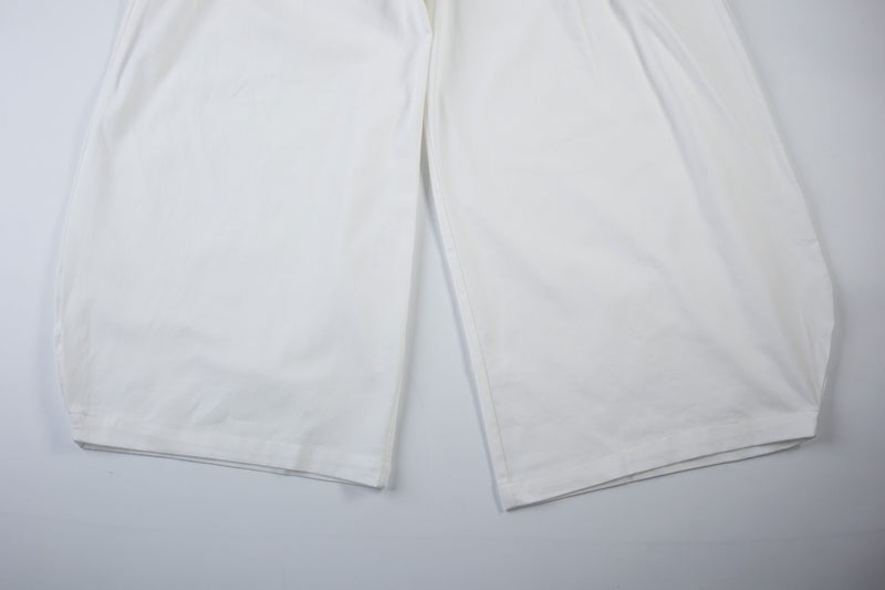 White wide-leg cargo pants laid flat, lower legs and hem view