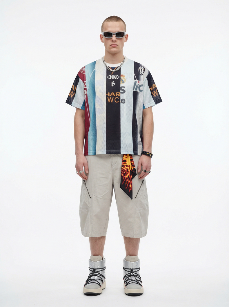 Model wearing a vintage patchwork football mesh jersey with striped panels, paired with beige cargo shorts and silver boots