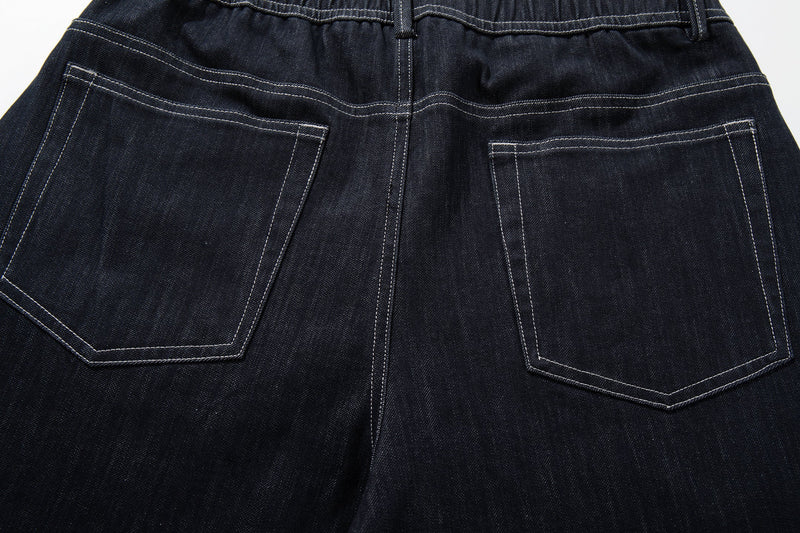 Close-up of the back patch pockets on dark denim jeans with contrast stitching