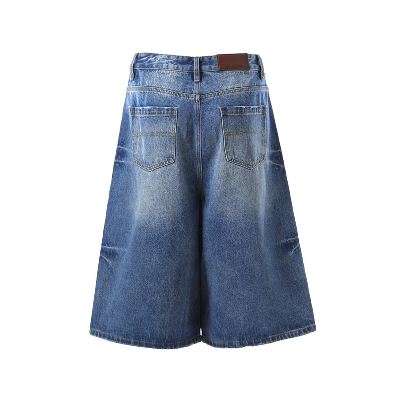 Dark wash denim shorts back view with patch pockets and tan waistband label