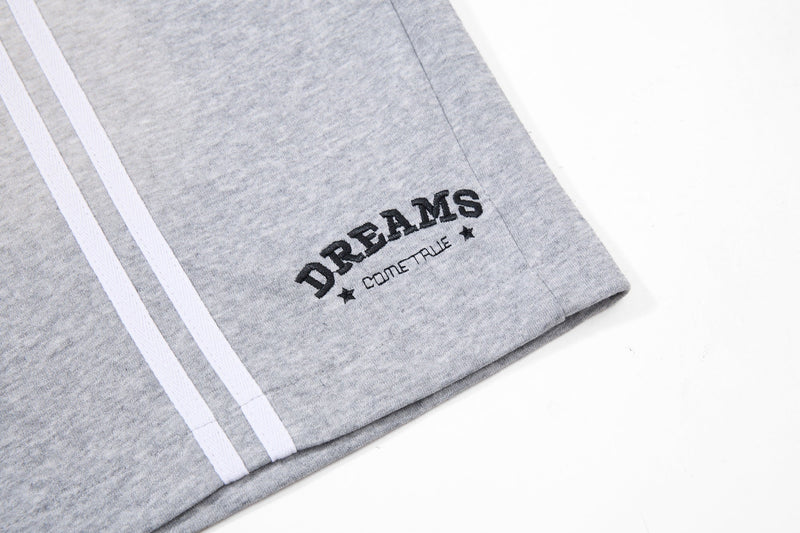 Close-up of gray side hem with white stripes and DREAMS embroidery