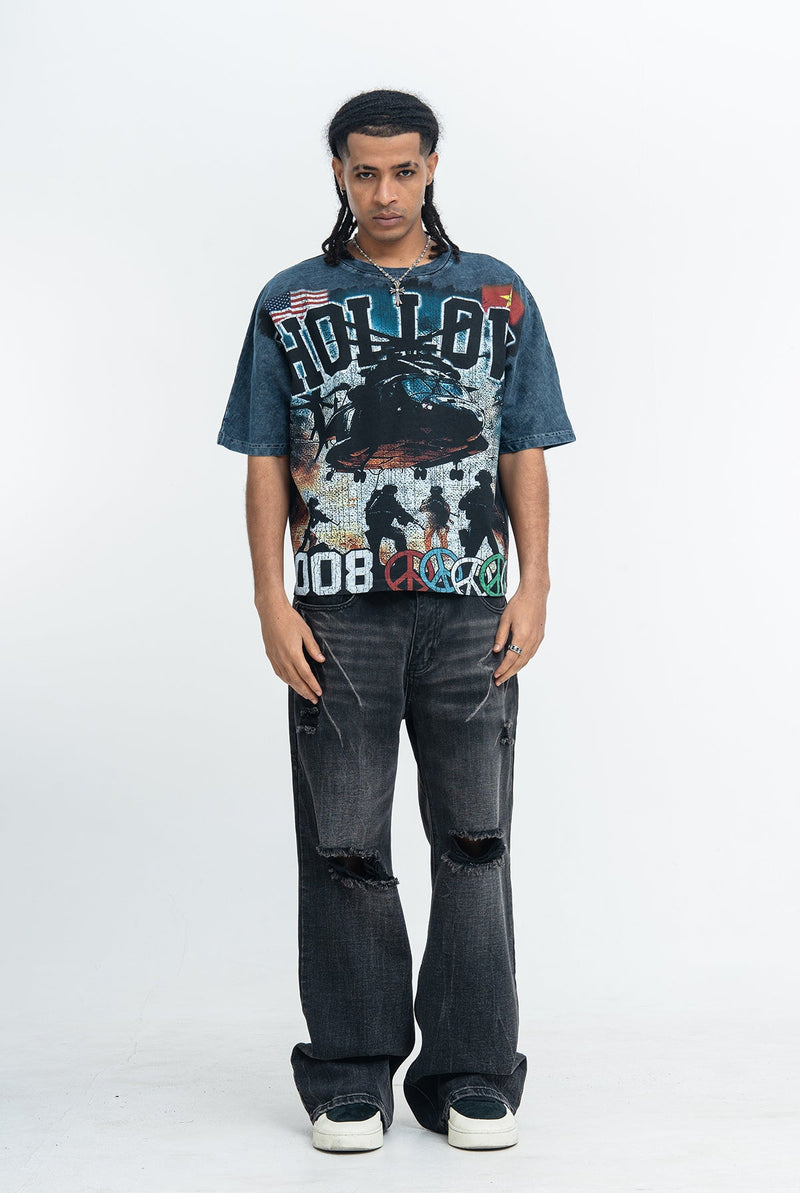 Vintage washed oversized graphic tee with war-themed print, worn with baggy distressed black jeans and sneakers