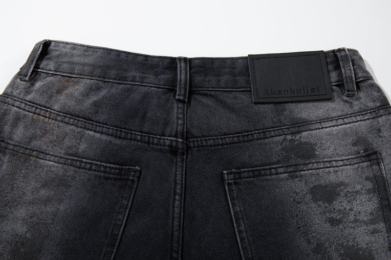 Close-up of the back waistband and upper pockets on dark washed jeans with a black patch label