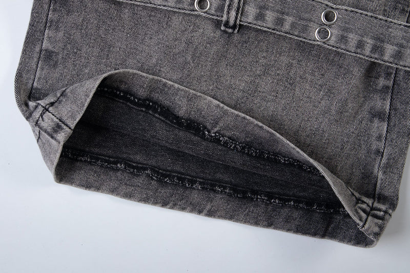 Hem close-up of washed black denim jeans with frayed inner seam and folded cuff