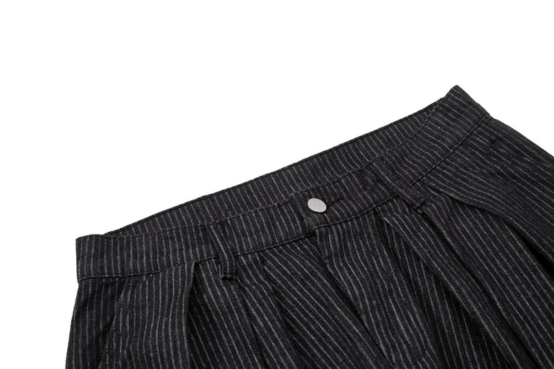Close-up of black pinstripe trouser waistband with silver button
