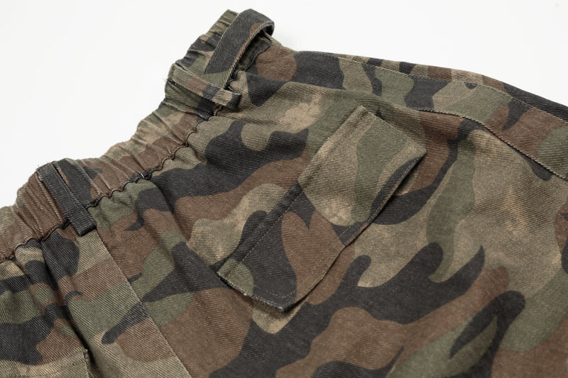 Close-up of cargo pocket and waistband buckle on green brown camo shorts