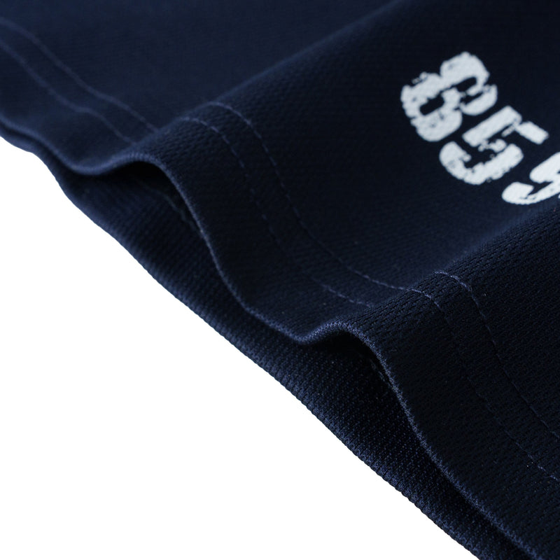 Close-up of a navy graphic polo tee with stitched hem and white Seakoff print on cotton fabric