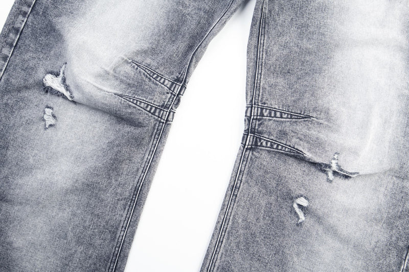 Close-up of ripped knee distressing on gray distressed baggy denim