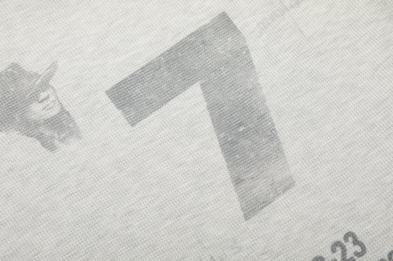 Close-up of large number 7 print on light gray waffle knit fabric