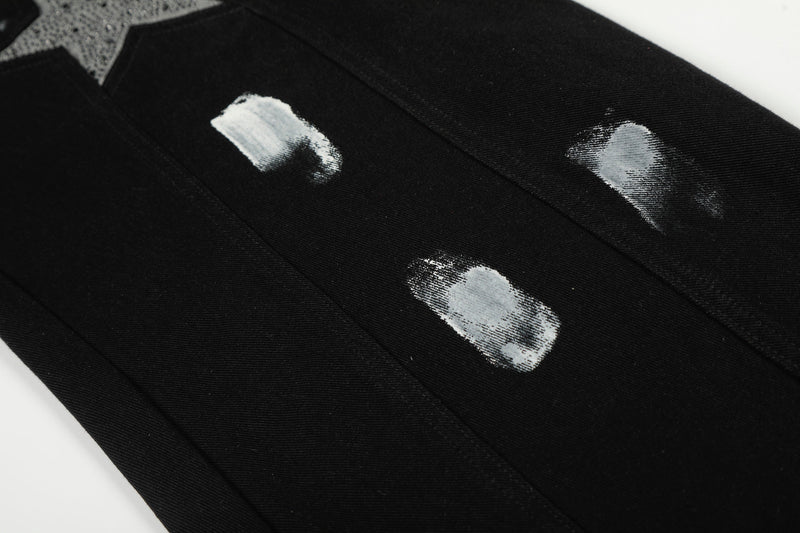 Close-up of black jeans leg with three white paint-like brush marks