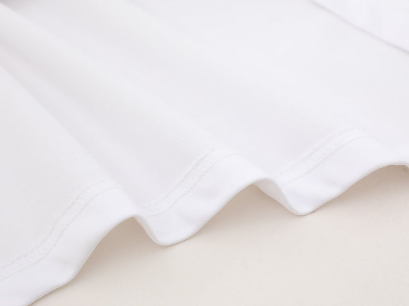 Close-up of white hem stitching and smooth knit fabric