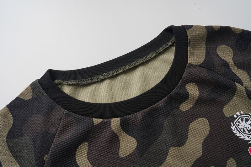 Close-up of black ribbed crew neckline and camo jersey shoulder seam