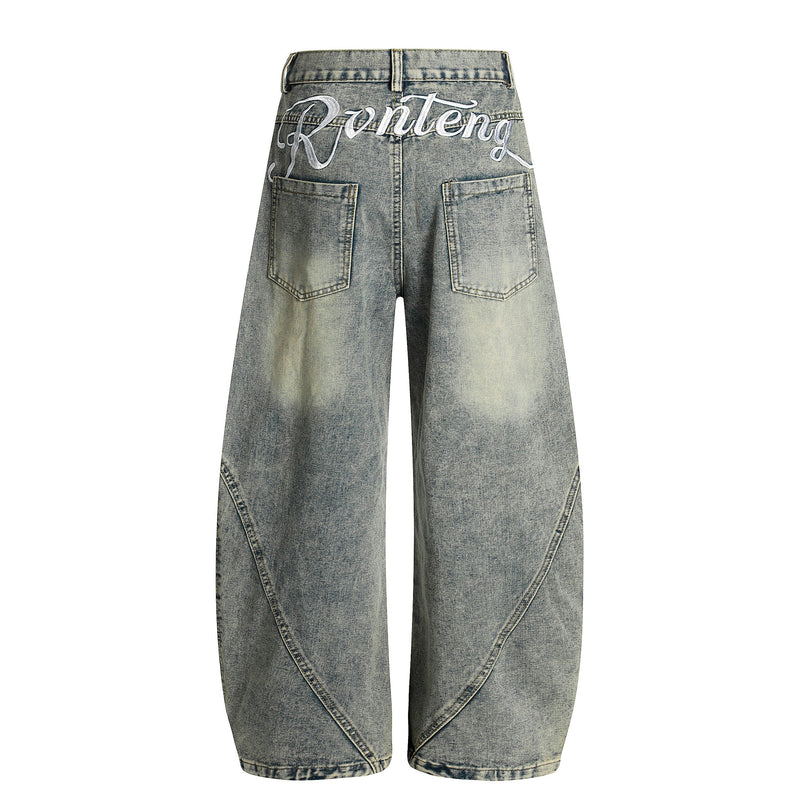 Light wash denim jeans back view with large rear patch pockets and white script embroidery