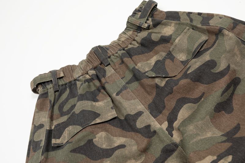 Close-up of side waistband and cargo pocket on green brown camo shorts